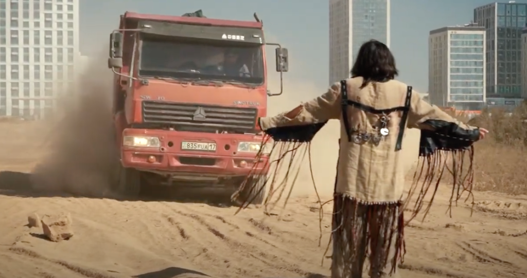 man in shaman clothes in front of a truck